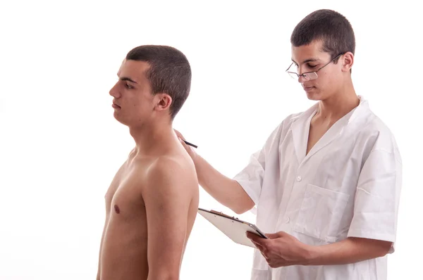 Teenager viene esaminato da un giovane medico, che annota il paziente sy — Foto Stock