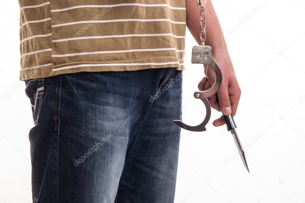 Close up of a man handcuffed with a knife in hand