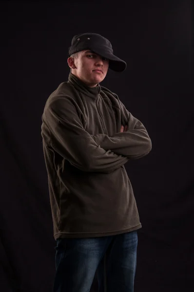 Serious teenager try to be cool standing with the cap put on one — Stock Photo, Image