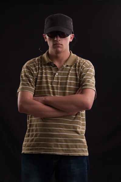 Ernster junger Mann mit Sonnenbrille und verschränkten Armen — Stockfoto