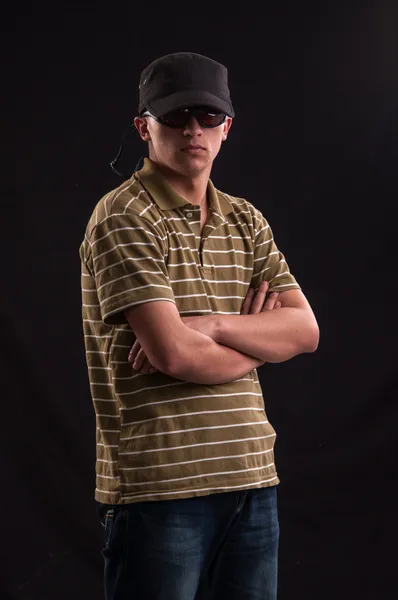 Sérieux jeune homme caucasien avec lunettes de soleil et chapeau de baseball — Photo