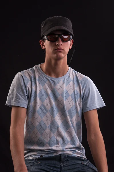 Hombre caucásico joven serio con gafas de sol y sombrero de béisbol — Foto de Stock