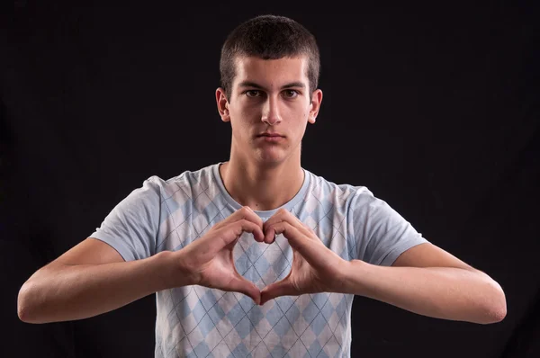 Portrait of a young man doing a heart gesture — Stock Photo, Image