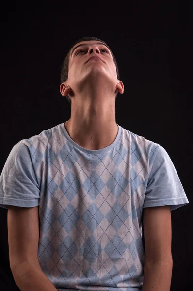 Serious and thoughtful teenage boy sits on chair, he thinks no o — Stock Photo, Image