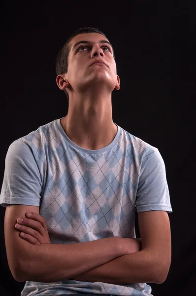 Serious and thoughtful teen boy with hands cross sits on chair — Stock Photo, Image