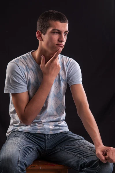 Teenage boy sits down and thinking about something — Stock Photo, Image