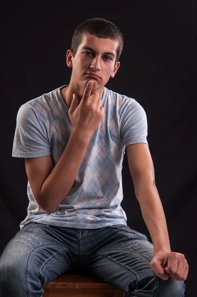 Teenage boy sits down and thinking about something — Stock Photo, Image