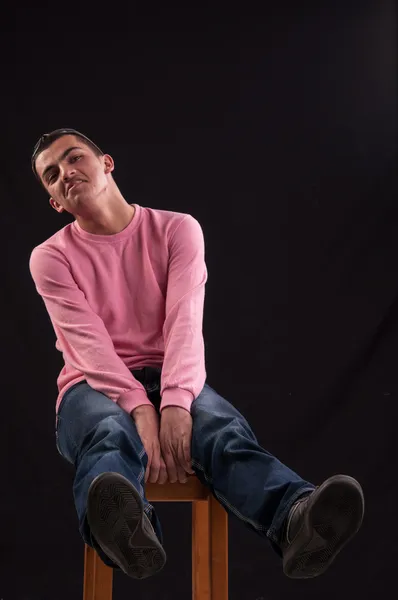 Young man who is foolishly, seated on the chair — Stock Photo, Image