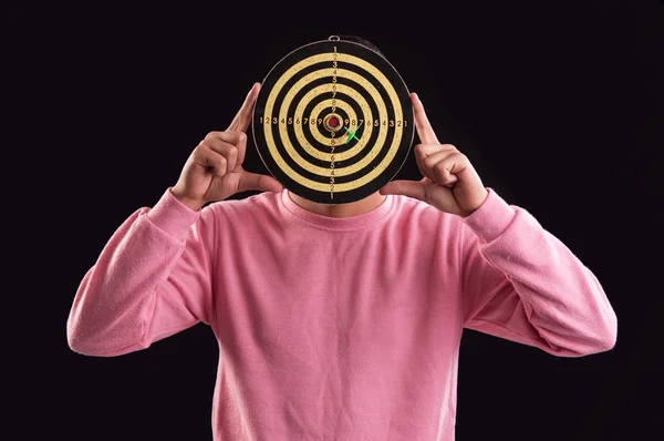 Portrait of teenager holding a dartboard over his face — Stock Photo, Image