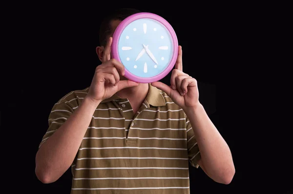 Manos de hombre sosteniendo en frente de su cara un gran reloj de pared showin — Foto de Stock
