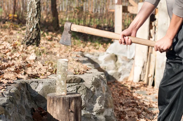 Junger Mann mit Axt hackt Holz zum Heizen — Stockfoto