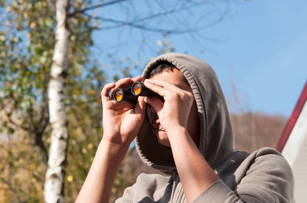 Joven con prismáticos observando la naturaleza, Hombre con binocula —  Fotos de Stock