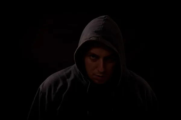 Portrait of a man in the dark looking straight at you with a sca — Stock Photo, Image