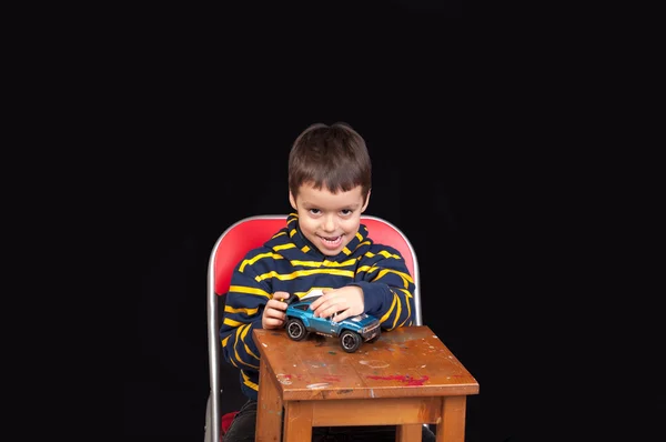 Malý chlapec hraje vnitřní s model vozu — Stock fotografie