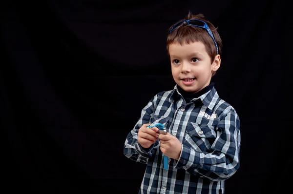 Happy kid with sunglasses on head keeping track of time with his — Stock Photo, Image