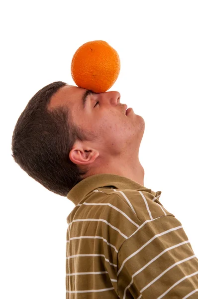 Jonge man spelen met oranje, houdt het op voorhoofd — Stockfoto