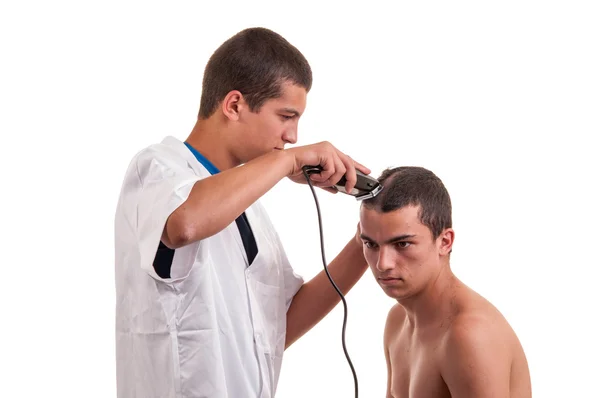 Hombre que tiene un corte de pelo con una cortadora de pelo sobre un fondo blanco —  Fotos de Stock