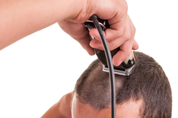 Hombre que tiene un corte de pelo con una cortadora de pelo sobre un fondo blanco —  Fotos de Stock