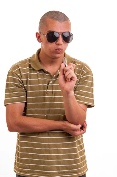 Young man blowing on the toy gun, he plays a police detective — Stock Photo, Image