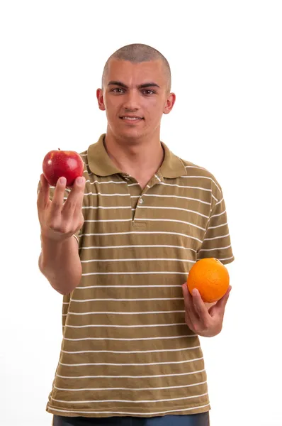 Студийный снимок молодого человека, который предлагает яблоки вместо апельсина , — стоковое фото