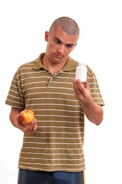 Мужчина предлагает таблетку в одной руке и яблоко в другой. Копирование пространства b — стоковое фото