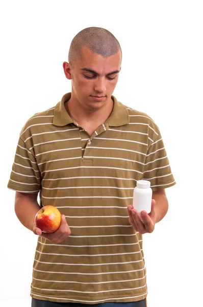 Мужчина предлагает таблетку в одной руке и яблоко в другой. Копирование пространства b — стоковое фото