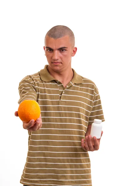 La elección correcta. joven sosteniendo una naranja en una mano y pi — Foto de Stock