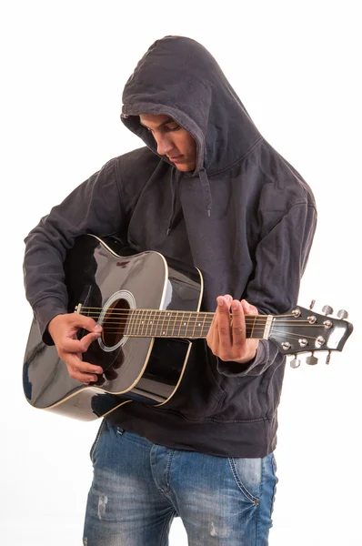 Triest tiener in hoodie akoestische gitaar spelen. proberen om te schrijven — Stockfoto