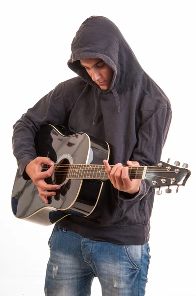 在声学吉他演奏的连帽衫的悲伤少年。试图写入 — 图库照片