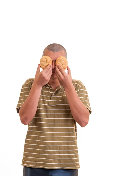 Young man keeps buns with sesame instead of the eyes, funny conc — Stock Photo, Image