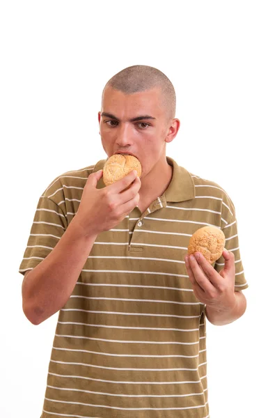 Young man eating buns with sesame — Stock Photo, Image