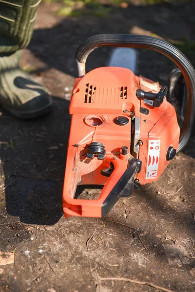 Orange motorsåg i trädgården. redo att arbeta — Stockfoto