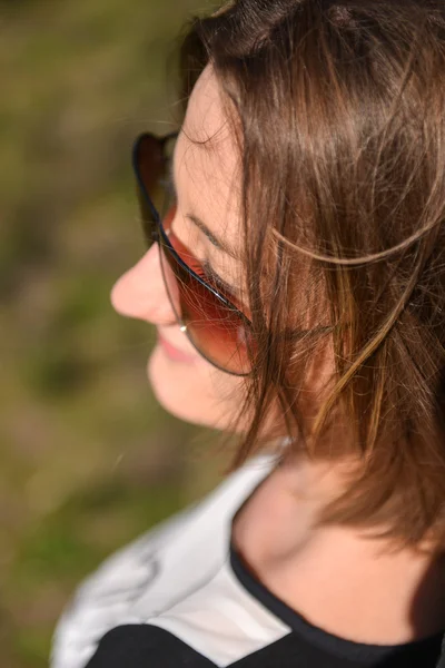 Portrait of brunette girl on sunny spring or summer day in park — Stock Photo, Image