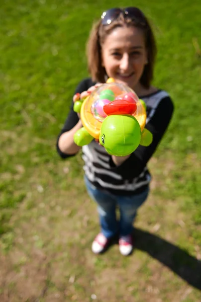 Woman hold in hand a toy turtle, focus on the turtle — Stock Photo, Image