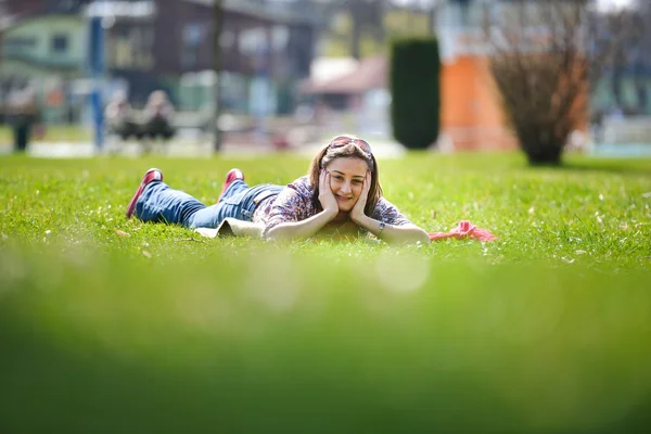 Młoda kobieta, leżąc na trawie w lecie. relaks na świeżym powietrzu — Zdjęcie stockowe