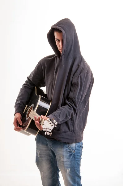 Adolescente triste com capuz tocando guitarra acústica — Fotografia de Stock