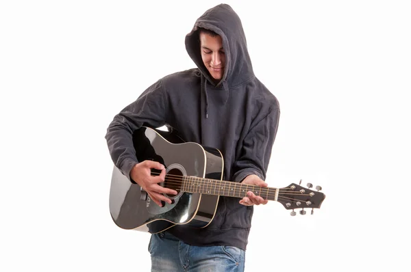 Young man dressed  in hoodie try to understand how to play acous — Stock Photo, Image