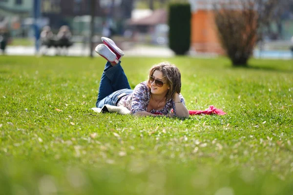 夏には草の上に横たわって若い女性。屋外でリラックスしました。 — ストック写真