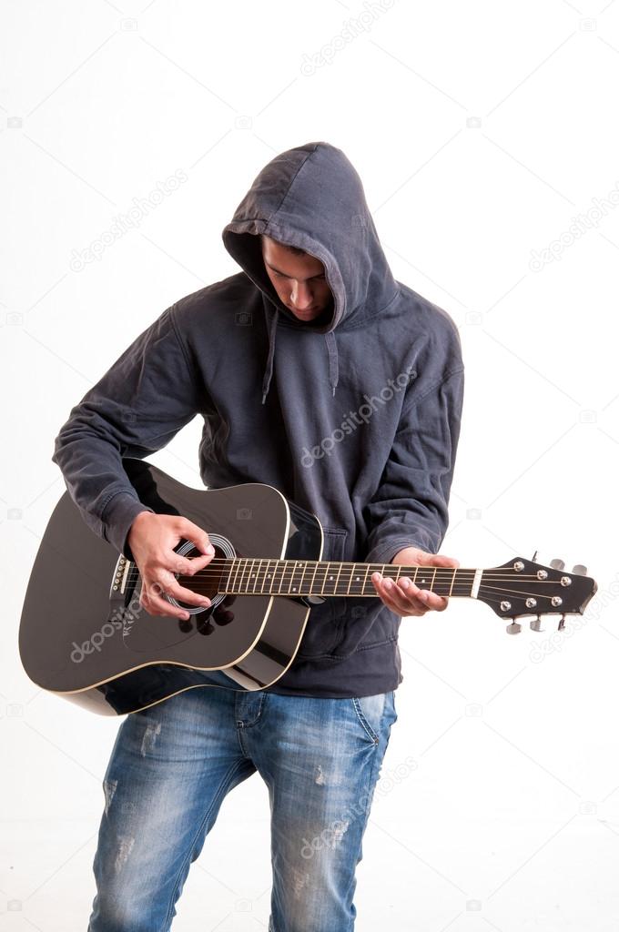 Practicing in playing guitar. Lonely young guitarist played by g