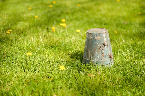 Jarní zahrada - převrácený květináč vzhůru nohama v trávě, copyspac — Stock fotografie