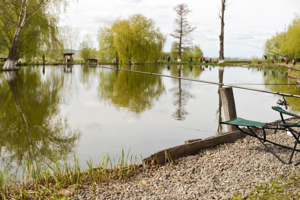 Cadeira com acessórios de pesca na costa do lago — Fotografia de Stock