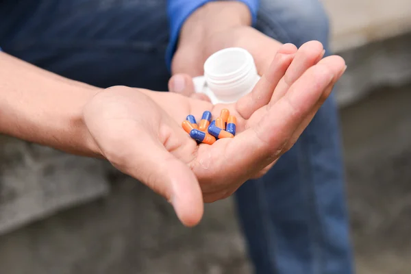 Depressed teenage boy with many tablets in hand, wants to take a — Stock Photo, Image