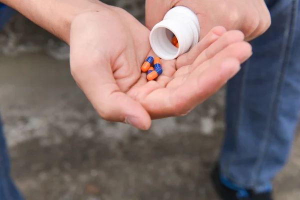 Depresi dospívající chlapec s mnoha tablety v ruce a chce, aby — Stock fotografie