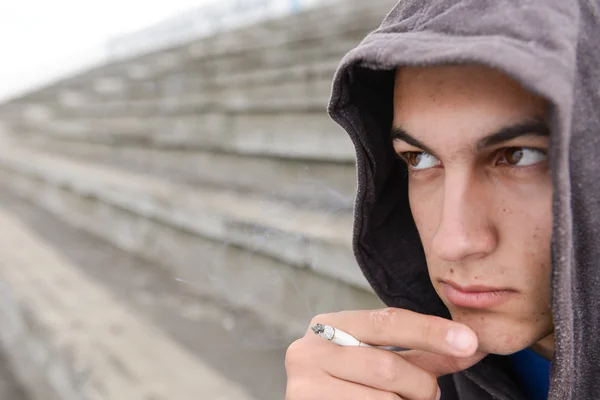 Dalgın ve endişeli genç siyah hoodie ile yasaktır çiğ çocuktur — Stok fotoğraf