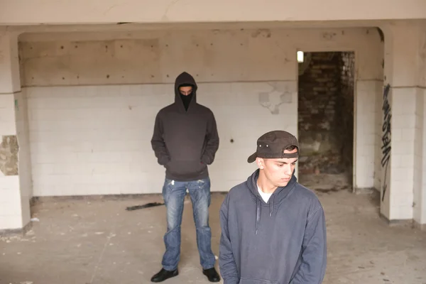 Two street hooligans or rappers standing in a old abandoned buil — Stock Photo, Image