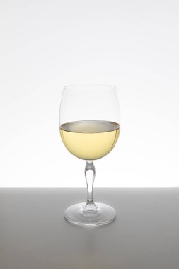 Beyaz arka planda bir bardak beyaz şarap.