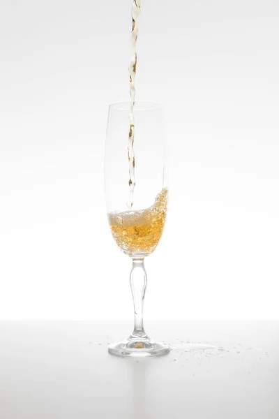 Şampanya beyaz arka planda camlara dökülüyor.