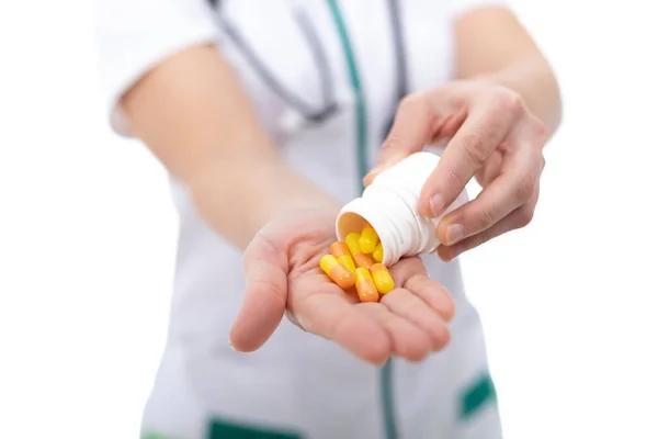 Doktor, hemşire ve eczacı eline ilaç döküyor..