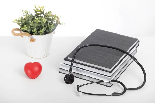 Tıp öğrencileri için ders kitapları, steteskop boş. Kırmızı kalp.