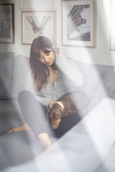 Küçük Dachshund köpeğini okşayan kız.